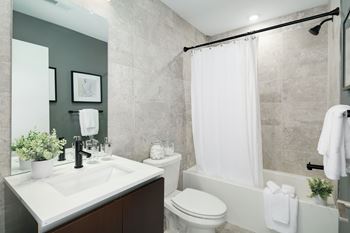 A bathroom with a white sink, toilet, and shower curtain.
